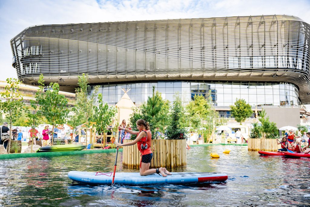 Une fille s'agenouille sur une planche de paddle sur le lac du Southampton Boat Show